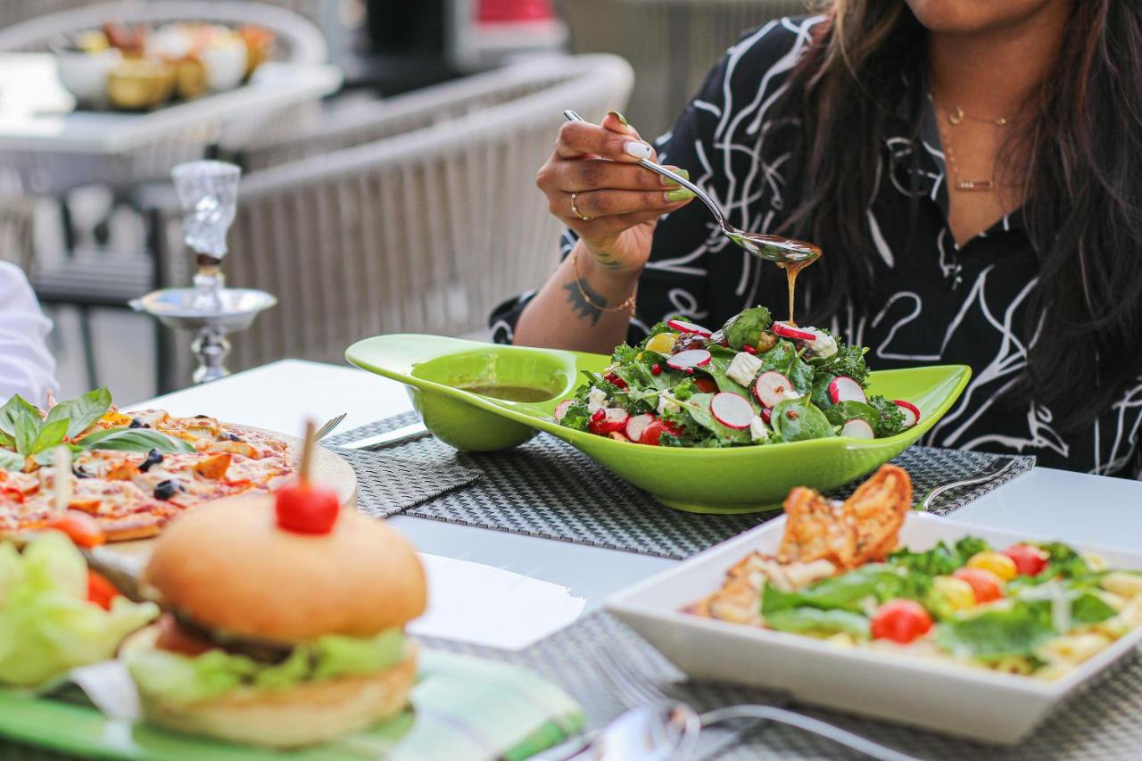 Majestic Arjaan By Rotana - Manama Aparthotel Exterior photo A woman seasoning a salad